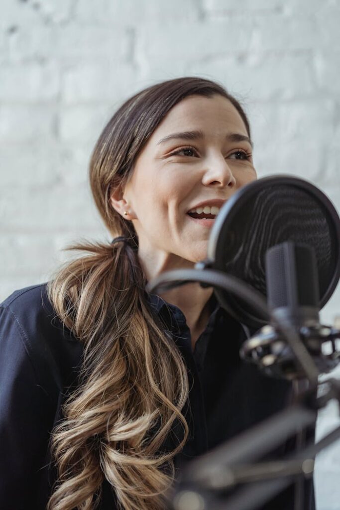 Happy woman talking while recording podcast in studio